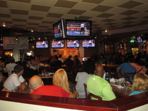 People watching TV at a restuarant. Restaurants are one industry who commonly use Surveillance and AV systems.